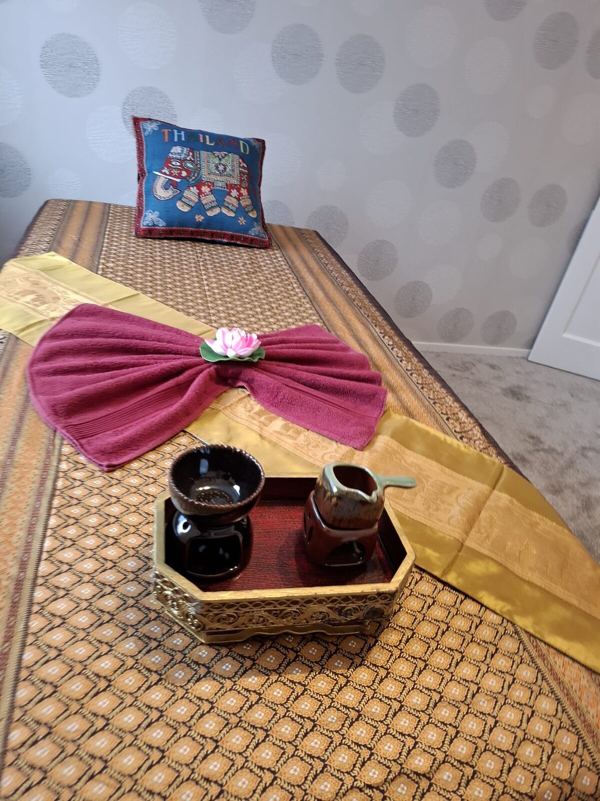 Massageliege mit Tee und thailändischen Details