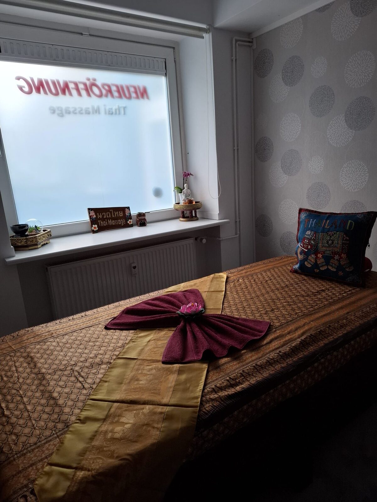 Ruhiges Studio mit thailändischem Massage-Schild am Fenster